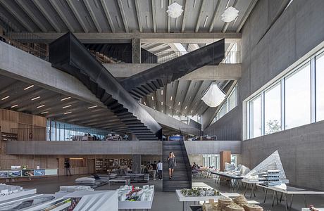 Dramatic concrete staircase and lighting fixtures in an expansive, modern interior space.