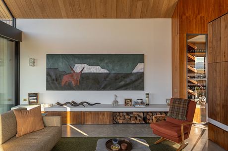 Cozy modern living room with wooden walls, artwork, and built-in fireplace storage.