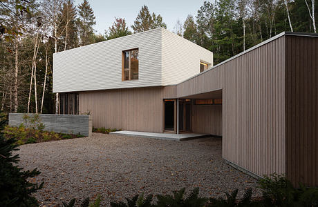 Modern, minimalist home design with clean lines, rectangular form, and contrasting wood and concrete materials.