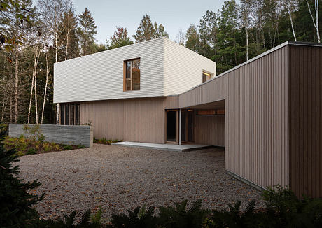 Modern, minimalist home design with clean lines, rectangular form, and contrasting wood and concrete materials.