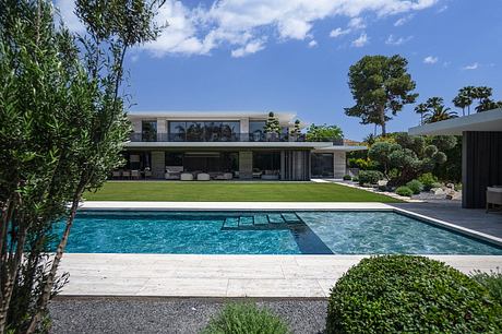 Luxurious poolside residence with modern architecture, lush landscaping, and sleek design.