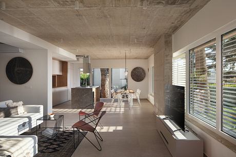 Spacious open-concept living area with exposed concrete ceiling and modern furnishings.