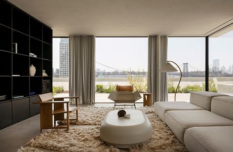 Stunning modern living room with floor-to-ceiling windows, plush furnishings, and cityscape view.