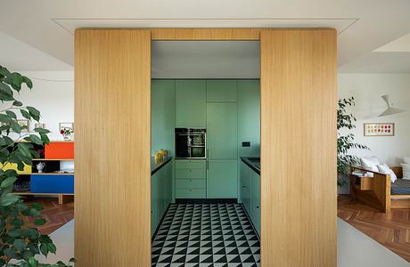 Sleek, minimalist kitchen design with wooden paneling and vibrant green cabinetry.