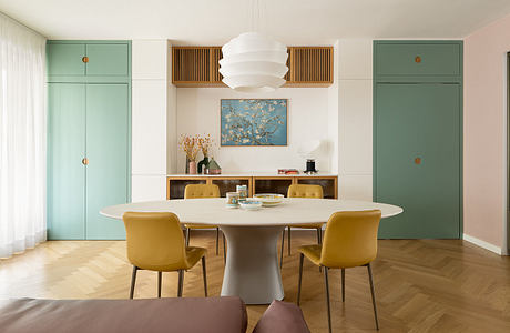 Inviting dining space with minimalist furnishings, wood paneling, and a striking chandelier.