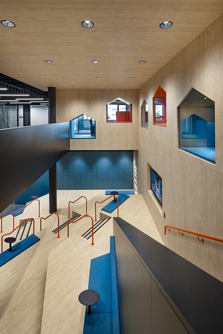Modernist interior with geometric shapes, recessed lighting, and colorful seating arrangements.