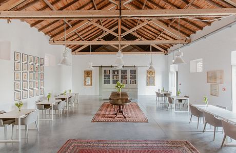 Spacious interior with ornate wooden ceiling, vintage furniture, and patterned rugs.