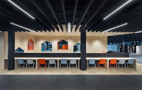 Modern and vibrant interior with colorful shelving units, sleek lighting, and a long counter seating area.