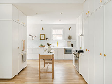 A bright, modern kitchen with white cabinets, wooden accents, and a minimalist decor.