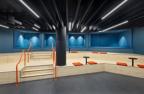 A sleek, modern interior with bold colors, geometric structures, and dramatic lighting.