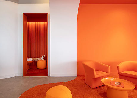 Vibrant orange color scheme with geometric shapes, textured surfaces, and built-in seating.