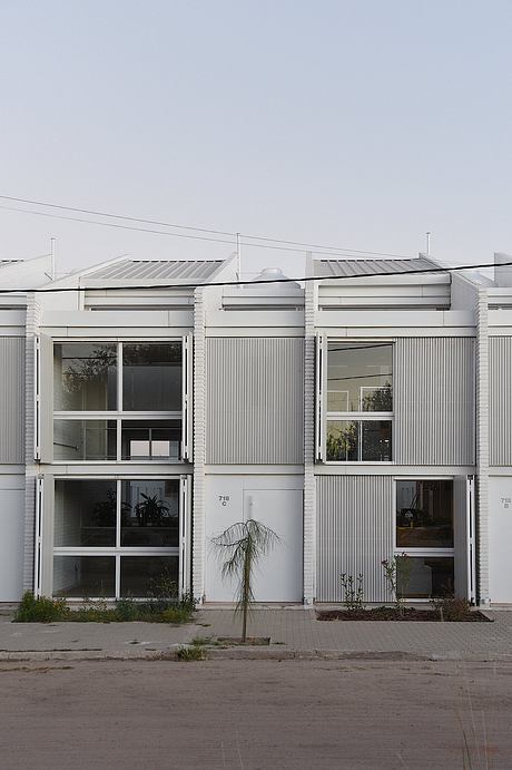 Modern industrial-style building with clean lines, striped facade, and minimalist windows.