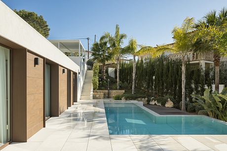 Modern architecture with clean lines, pool, and lush tropical landscaping.