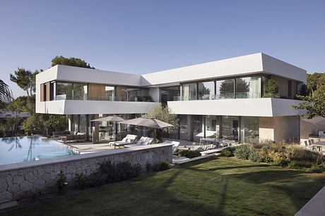 Modern, multi-level residence with sleek, geometric design, expansive glass walls, and pool.