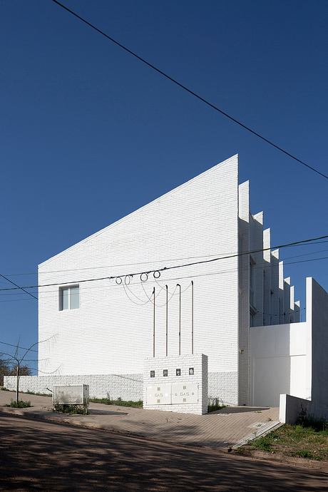 A striking white building with bold geometric shapes and clean lines against a blue sky.