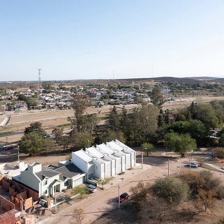 A small town nestled in a hilly landscape, with a mix of modern and traditional architecture.