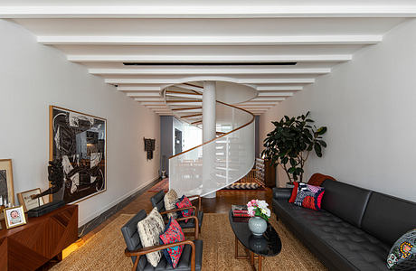 Striking modern interior with spiral staircase, recessed lighting, and eclectic furnishings.