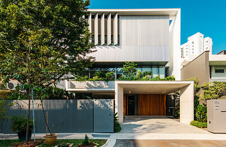 A modern, multi-story building with a striking facade and lush landscaping surrounding the entrance.