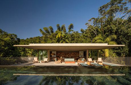 Stunning modern pavilion with floor-to-ceiling glass walls, surrounded by lush tropical greenery.