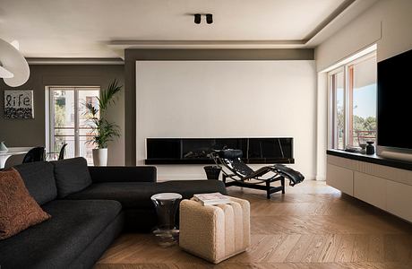 Elegant living room with modern furniture, fireplace, and large windows overlooking a scenic view.