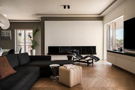 Elegant living room with modern furniture, fireplace, and large windows overlooking a scenic view.