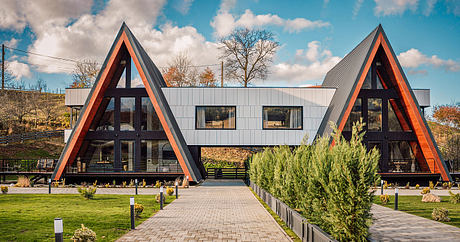 A modern, A-frame building with sleek exterior, glass walls, and landscaped surroundings.