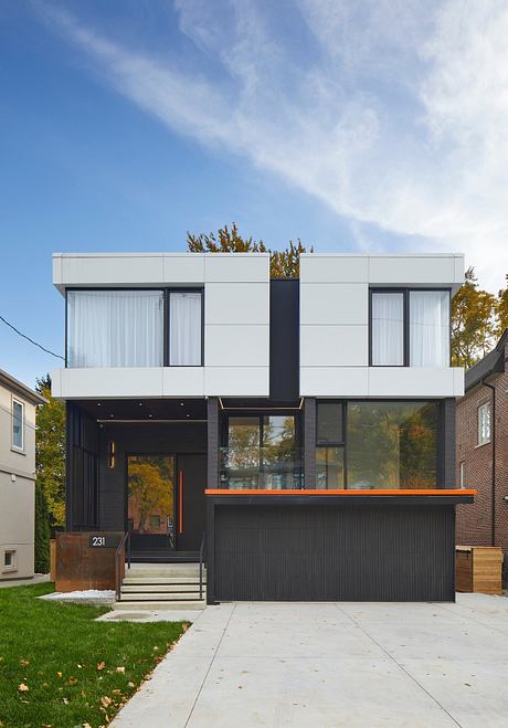 Sleek, modern, two-story home with clean lines, large windows, and striking contrast between light and dark materials.