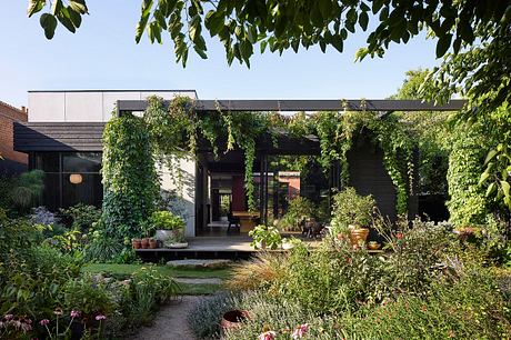 A modern, glass-enclosed structure with a lush, verdant garden surrounding it.