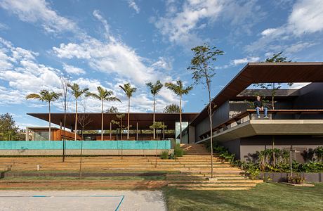 Modern architectural design with cantilevered roof, palm trees, and tiered landscaping.