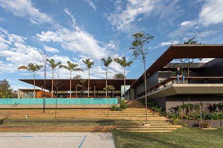 Modern architectural design with cantilevered roof, palm trees, and tiered landscaping.