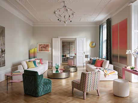 Ornate ceiling, vibrant furnishings, and herringbone floors in this elegant living room.