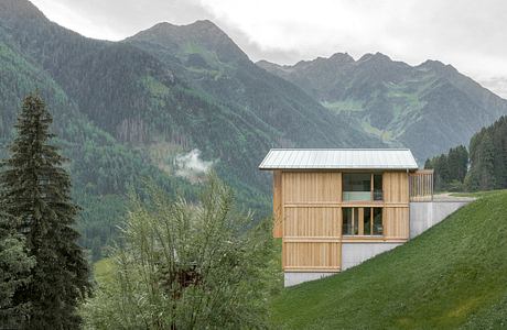 Striking wooden structure blending seamlessly with the rugged mountainous landscape.