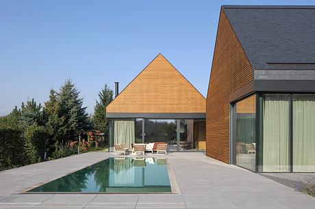 Contemporary home with striking triangular roof, sleek glass walls, and minimal pool.