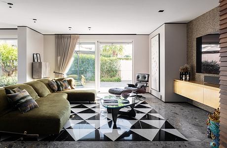 Modern living room with geometric tile flooring, large sofa, and sliding glass door to backyard.