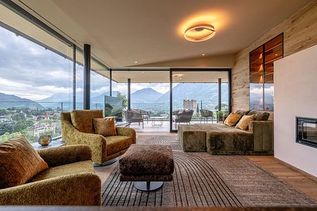 Spacious living room with panoramic mountain views, modern furniture, and cozy textures.