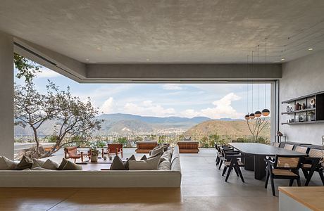 Spacious modern living room with panoramic mountain view and contemporary furnishings.