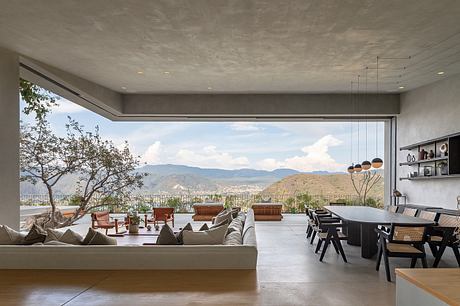 Spacious modern living room with panoramic mountain view and contemporary furnishings.