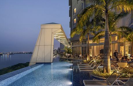 An opulent outdoor pool area with modern architectural features and tropical landscaping.