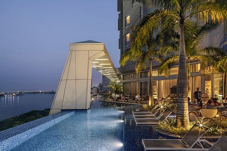 An opulent outdoor pool area with modern architectural features and tropical landscaping.