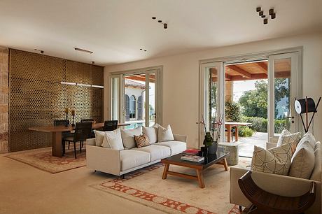 Elegant open-concept living room with patterned accent wall, modern furnishings, and floor-to-ceiling windows.