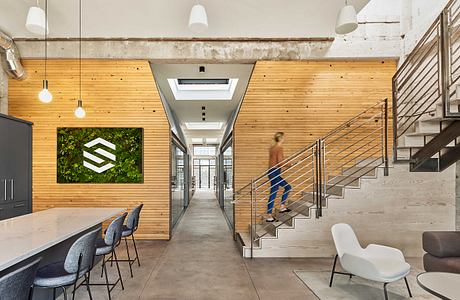 Minimalist office interior with rustic wooden walls, sleek stairs, and modern design elements.