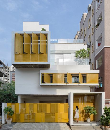 Striking modern architecture with vibrant yellow accents and creative balcony designs.