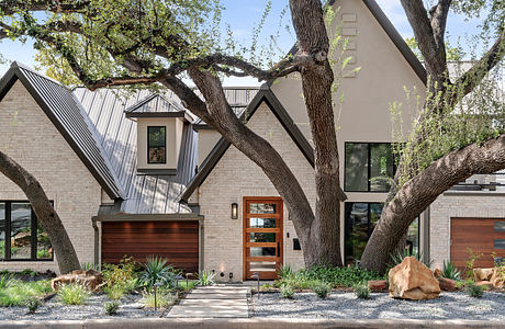 Striking modern home design with asymmetric roofline, wooden accents, and lush landscaping.