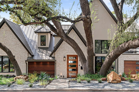 Striking modern home design with asymmetric roofline, wooden accents, and lush landscaping.