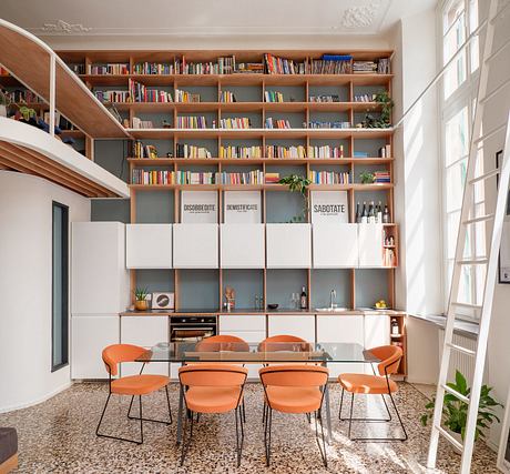 Cozy modern dining room with built-in bookshelves, orange chairs, and concrete floors.