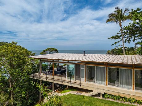 Elevated tropical modern home with expansive deck and panoramic ocean views.