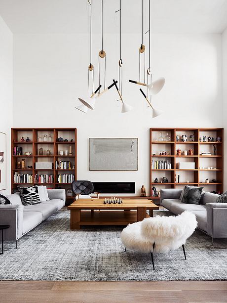 Sleek, modern living room with minimalist lighting, wooden shelves, and plush furnishings.