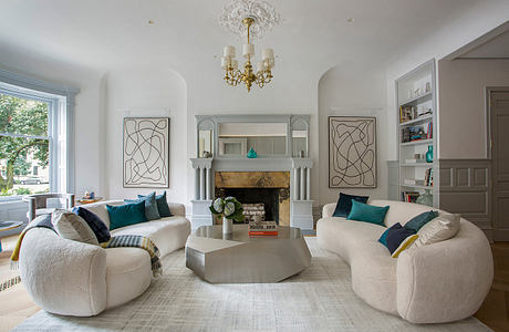 Elegant living room with ornate chandelier, built-in shelving, and abstract wall art.