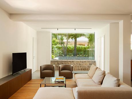 Bright, open living space with floor-to-ceiling window showcasing lush, outdoor garden.