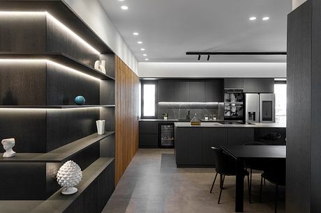 Sleek, modern kitchen with dark cabinetry, wooden accents, and recessed lighting.